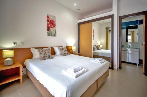 a bedroom with a large bed with two towels on it at Villa Rafaella II Palace in Albufeira