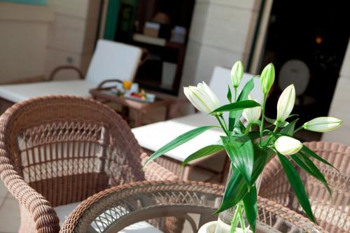 a vase of flowers sitting on a table with chairs at Las Arenas Balneario Resort in Valencia