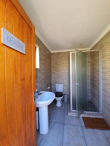 a bathroom with a sink and a toilet and a shower at Lebo's Soweto Backpackers in Soweto