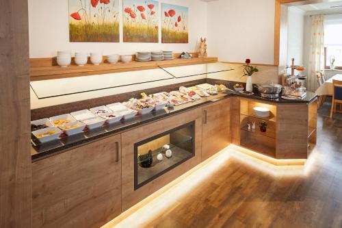 a kitchen with many plates of food on a counter at Hotel & Ferienappartements Edelweiss in Willingen