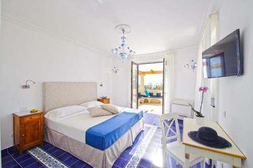 a bedroom with a bed and a table and a tv at Villa Duchessa di Amalfi in Conca dei Marini
