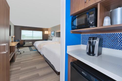 a hotel room with a bed and a microwave at Holiday Inn Express- Eau Claire West I-94 by IHG in Eau Claire