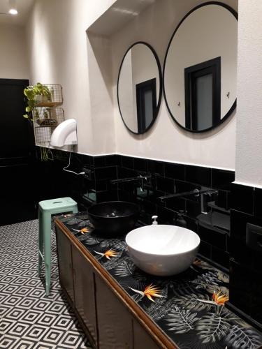 La salle de bains est pourvue d'un lavabo et de 2 miroirs sur le mur. dans l'établissement 5 Terre Backpackers City, à La Spezia