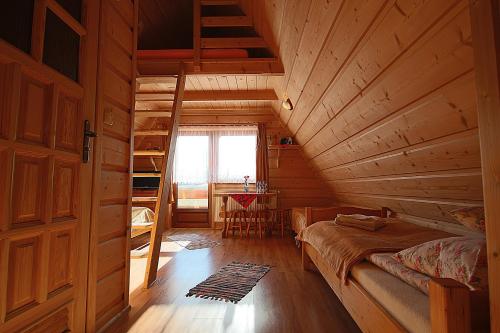 a bedroom with a bed in a wooden cabin at Leśne Zacisze in Murzasichle