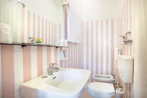 a bathroom with a sink and a toilet at Hotel Las Vegas in Lido di Jesolo