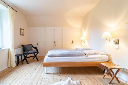a bedroom with a bed and a chair at Landhaus Camillas Höhe in Mirbach