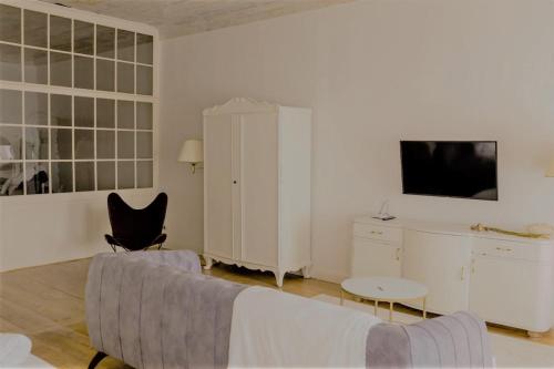 a white living room with a couch and a chair at Apartments 1620yr Trnava in Trnava
