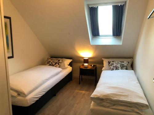 two beds in a small room with a window at Fennies Hütte in Medebach