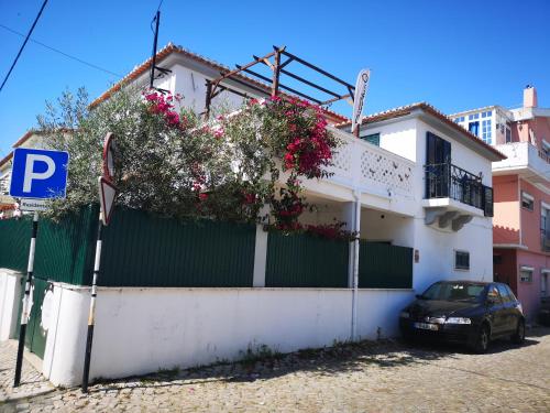 ein Haus mit Blumen auf der Seite in der Unterkunft Caparica Surf Villa in Costa da Caparica