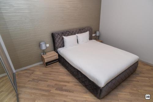 a bedroom with a bed with white sheets and pillows at Roof terrace apartment in Panevėžys