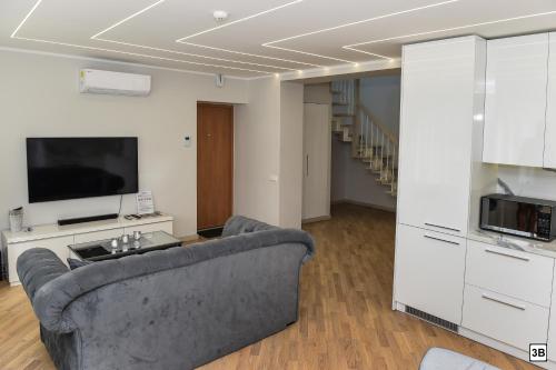 a living room with a couch and a tv at Roof terrace apartment in Panevėžys