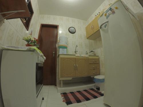a small kitchen with a sink and a refrigerator at Casa verde mar in Arraial do Cabo