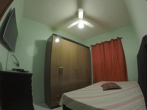 a bedroom with a bed and a wooden cabinet at Casa verde mar in Arraial do Cabo