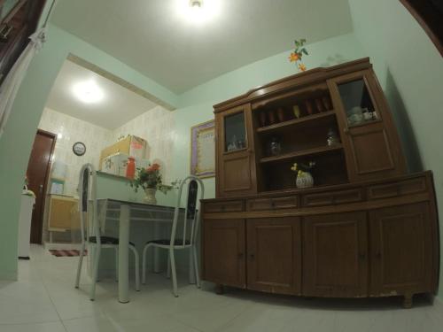 una cocina con un gran armario de madera y una mesa en Casa verde mar en Arraial do Cabo