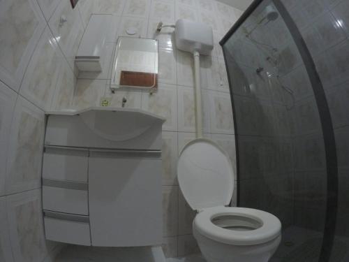 a small bathroom with a toilet and a sink at Casa verde mar in Arraial do Cabo