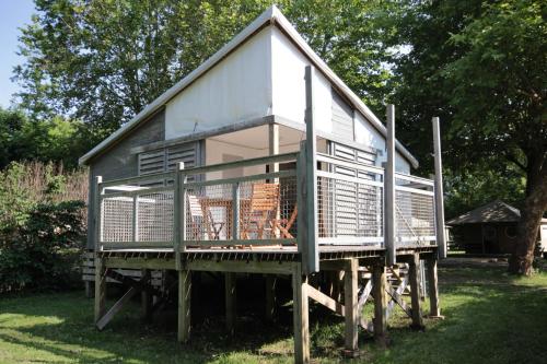 een klein huisje bovenop een pier bij Camping L'îlot du Chail in Sansais