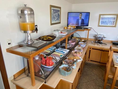ein Buffet mit Speisen auf einem Schreibtisch in einem Zimmer in der Unterkunft HOTEL VARGINHA in Varginha