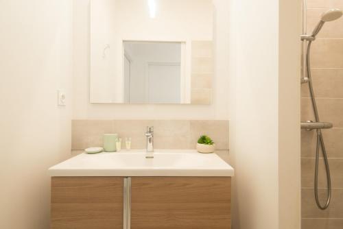 a bathroom with a sink and a mirror at "Le Soleil Levant" avec balcon et parking privé, 2 adultes et 1 enfant in Sarlat-la-Canéda