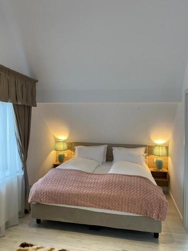 a bedroom with a large bed with two lamps at ApartamentS in Râşnov