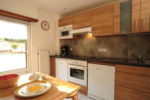 a kitchen with wooden cabinets and a wooden table at Au Pied du Chateau in Lichtenberg