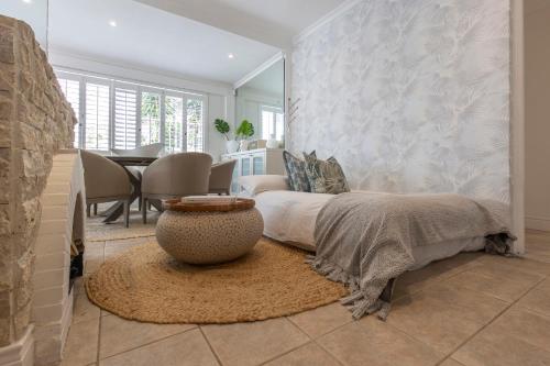 a bedroom with a bed and a vase on a rug at Clifton YOLO Spaces - Clifton Boutique Apartments in Cape Town