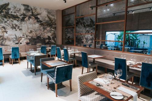 a dining room with tables and chairs and a wall mural at La Laguna Gran Hotel in La Laguna