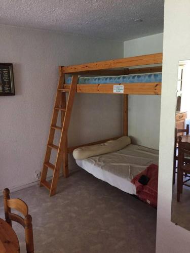 une chambre avec deux lits superposés et une échelle dans l'établissement bel appartement du sancy, à Le Mont-Dore