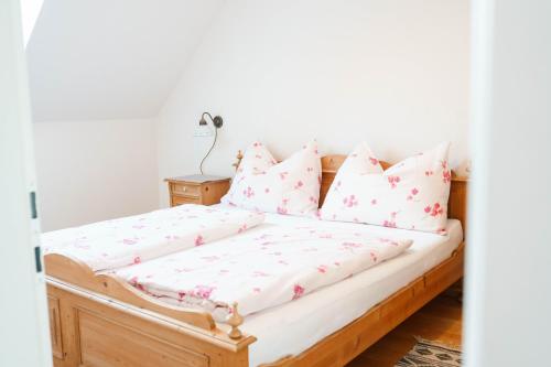 a bedroom with a bed with pink and white pillows at Weingut Leopold Dietrich in Gamlitz