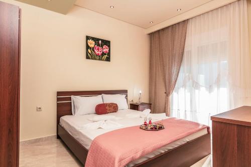 a bedroom with a bed with a pink blanket at Loridis View Apartments in Prinos