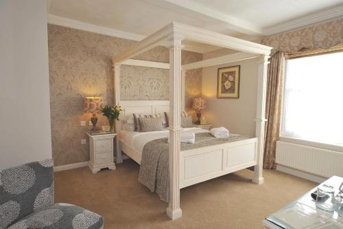 a bedroom with a canopy bed and a window at Le Bouchon Brasserie & Hotel in Maldon