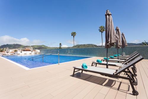 a beach with a pool and a bench at La Laguna Gran Hotel in Las Lagunas