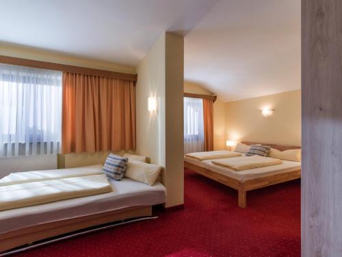 a hotel room with two beds and a window at Pension Elisabeth in Westendorf