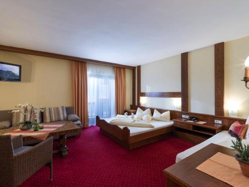 ein Hotelzimmer mit einem großen Bett und einer Couch in der Unterkunft Pension Elisabeth in Westendorf