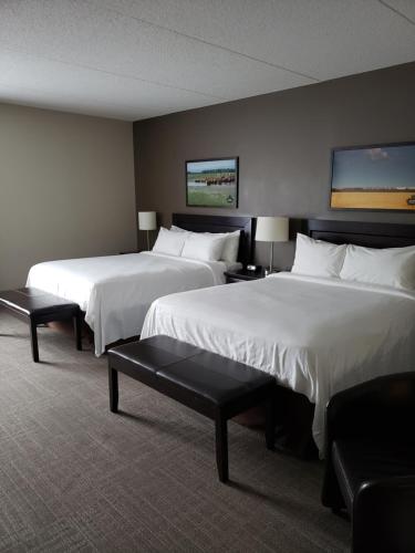 two beds in a hotel room with white sheets at Canad Inns Health Sciences Centre in Winnipeg