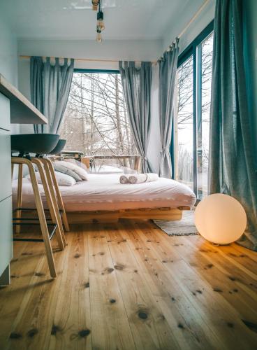 um quarto com uma cama e uma grande janela em LushHills - Tiny House - Modern House On Wheels em Regulice