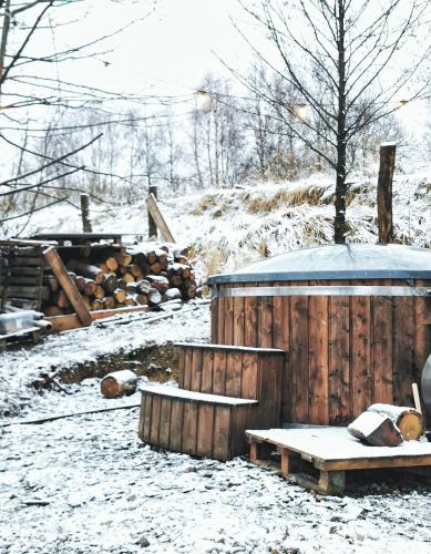 a snow covered yard with a wooden fence and a bench at LushHills - Tiny House - Modern House On Wheels in Regulice