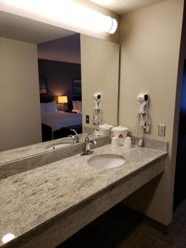 a bathroom with a sink and a large mirror at Canad Inns Health Sciences Centre in Winnipeg