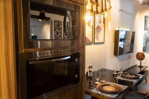 een keuken met een magnetron en een tafel met glazen bij The Royal 213 - Downtown República - Centro - SP in Sao Paulo