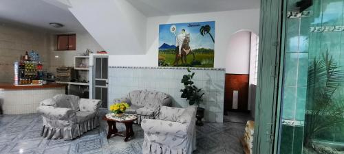 a living room with two chairs and a table at Hostal Las Palmeras in Jaén