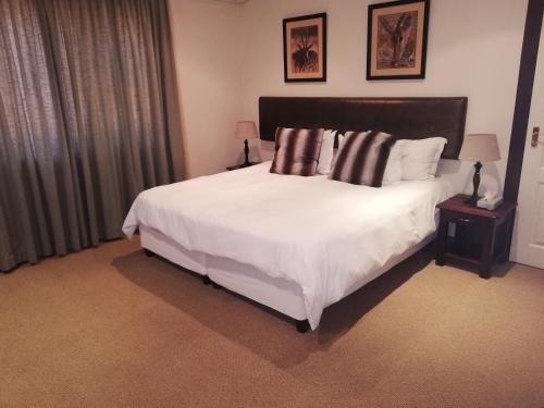 En eller flere senger på et rom på Kalahari Lodge Kimberley