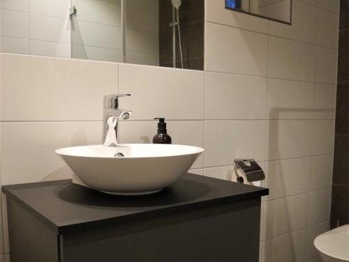 a white bowl sink on a black counter in a bathroom at Skäftekärr Hotell och Konferens in Löttorp