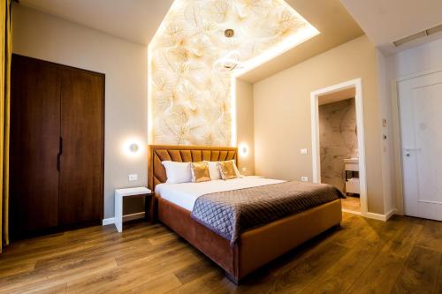 a bedroom with a large bed with a large ceiling at Hotel Bonsai in Tirana