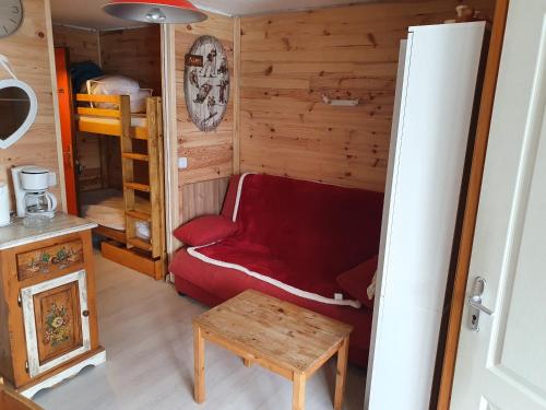マニグードにあるAppartement Combes Blanche 2のリビングルーム(赤いソファ、二段ベッド付)