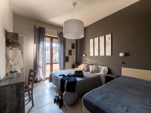 a bedroom with two beds and a large window at Appartamenti Villa Tonni in Gabicce Mare