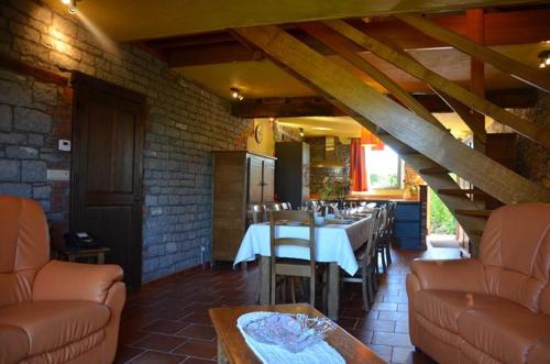 a restaurant with a table and chairs in a room at Gîtes Ferme de la Barrière in Chimay