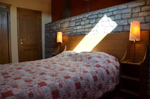 a bedroom with a bed and a brick wall at Gîtes Ferme de la Barrière in Chimay