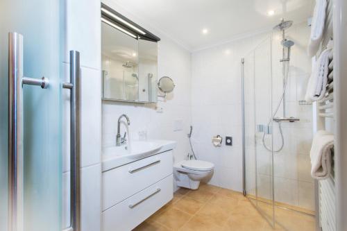 a bathroom with a sink and a toilet and a shower at Neue Post - Apartments in Zell am See