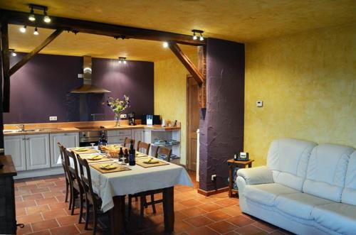 ein Wohnzimmer mit einem Tisch und einem Sofa in der Unterkunft Gîtes Ferme de la Barrière in Chimay