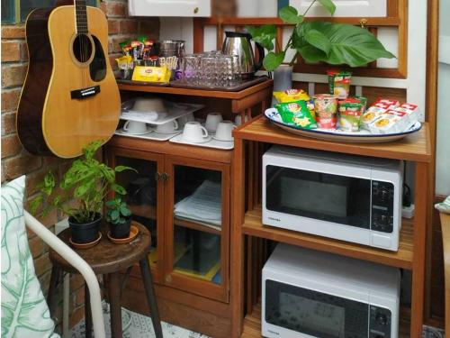 kuchnia z kuchenką mikrofalową i gitarą w obiekcie The Little Cottage 47 w mieście Bangkok