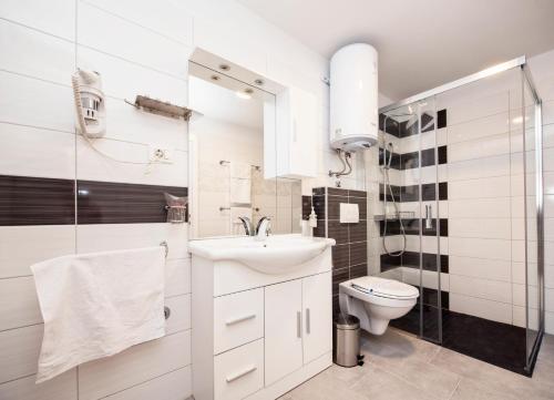 a white bathroom with a sink and a toilet at Apartment Piccolo Paradiso in Split